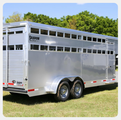 A shadow trailer is parked in a grassy field