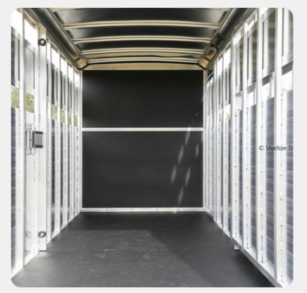 A long narrow hallway with a black door