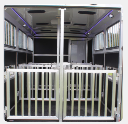 The inside of a trailer with a fence and lights on the ceiling