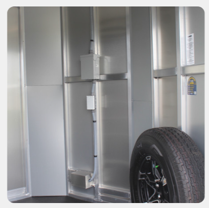 A tire is sitting on the side of a trailer.