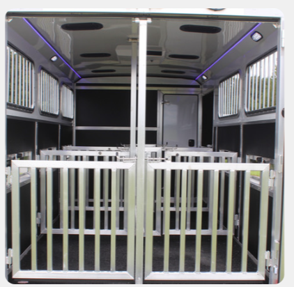 The inside of a horse trailer with the doors open