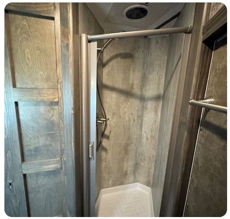 A bathroom with a shower and a mirror.