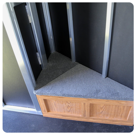 A corner of a room with a wooden cabinet underneath it