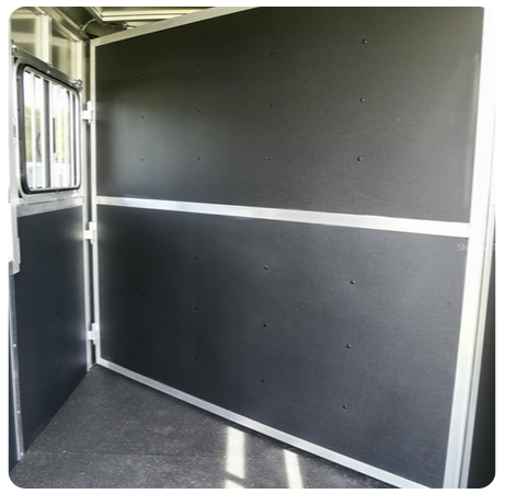 The inside of a horse trailer with a black wall