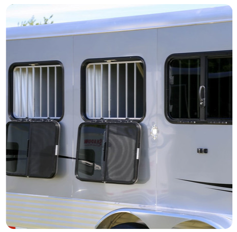 A horse trailer with the doors open and bars on the windows