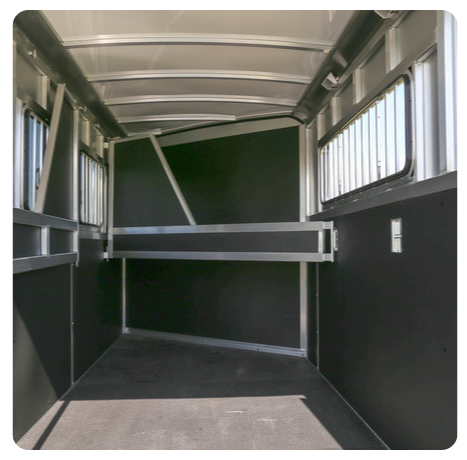 The inside of a horse trailer with a lot of windows