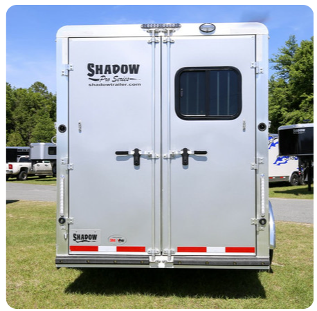 The back of a silver trailer with the word shadow on it.