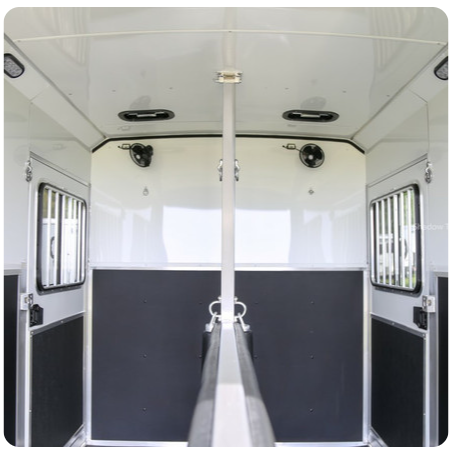 The inside of a horse trailer with a r on the door