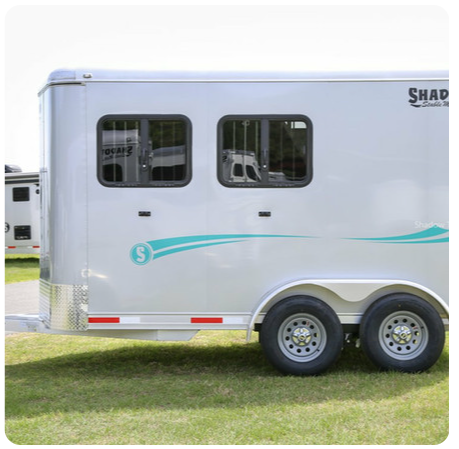 A shap trailer is parked in a grassy field