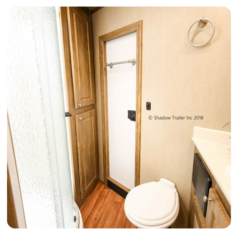 A bathroom with a toilet , sink and cabinets.