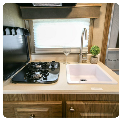 A kitchen with a stove top oven and a sink