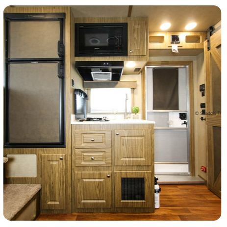 A kitchen with wooden cabinets and a microwave
