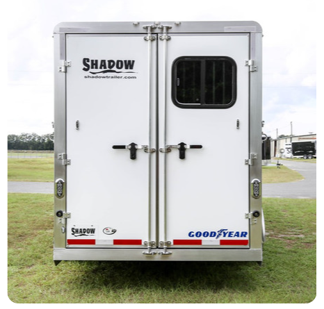 The back of a white trailer that says shadow on it