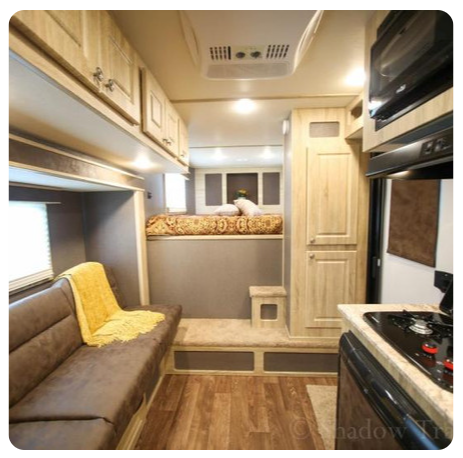 The inside of a rv with a couch and a microwave