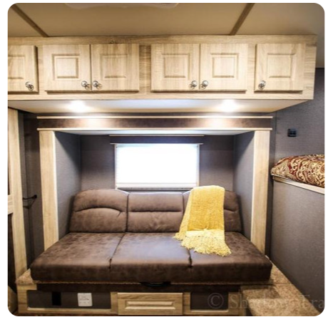 A brown couch with a yellow blanket on it