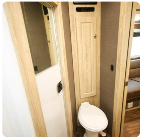 A bathroom with a toilet and a mirror