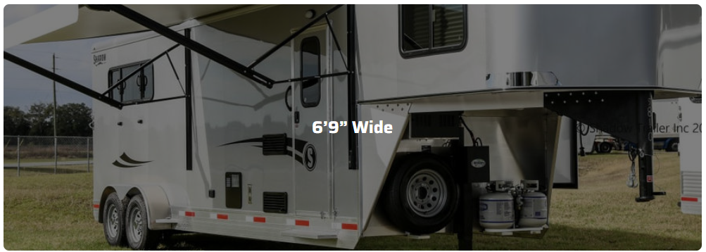 A horse trailer is parked in a grassy field.
