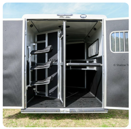 The inside of a horse trailer with the doors open