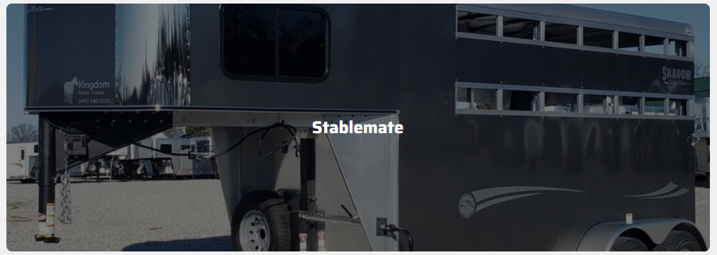 A horse trailer is parked on the side of the road.