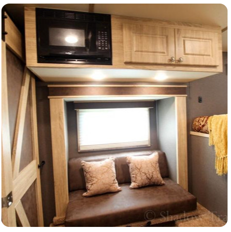 A living room with a couch and a microwave above it