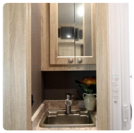 A kitchen sink with a mirror above it