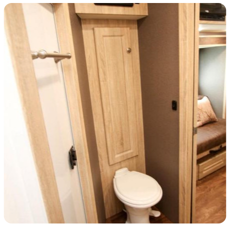 A bathroom with a toilet and a wooden cabinet