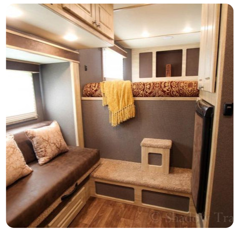 A picture of a rv with a couch and a bed