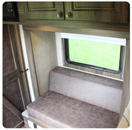 A couch in a room with a window and cabinets