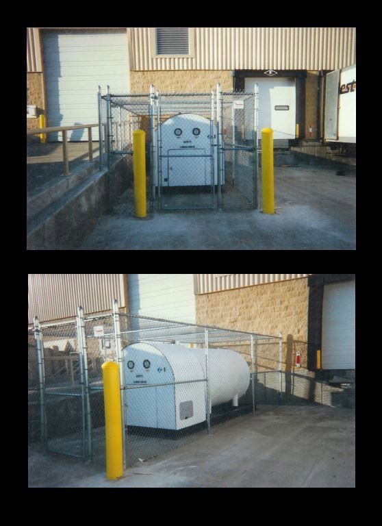 A white container with a face on it is behind a fence.