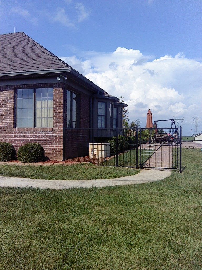 A brick house with a fence in front of it.