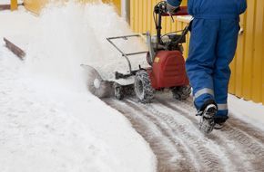 A person operating a snow blower