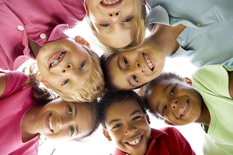 A group of children are standing in a circle and smiling