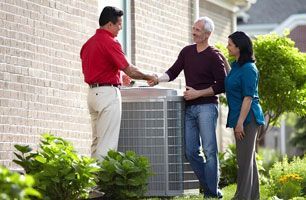 Two men are shaking hands while a woman stands beside them