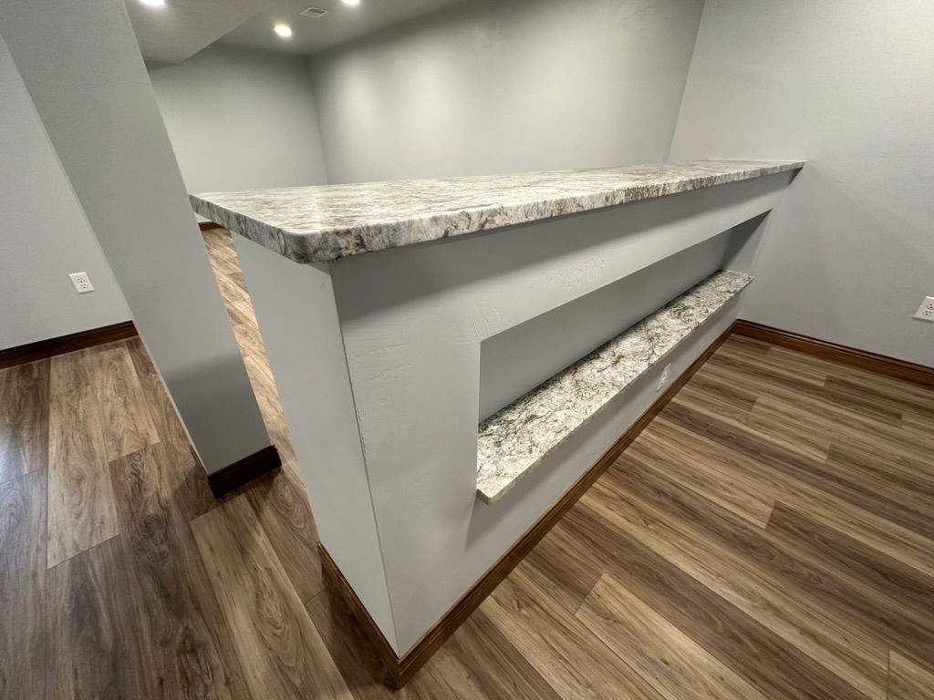 A room with hardwood floors and a marble counter top.