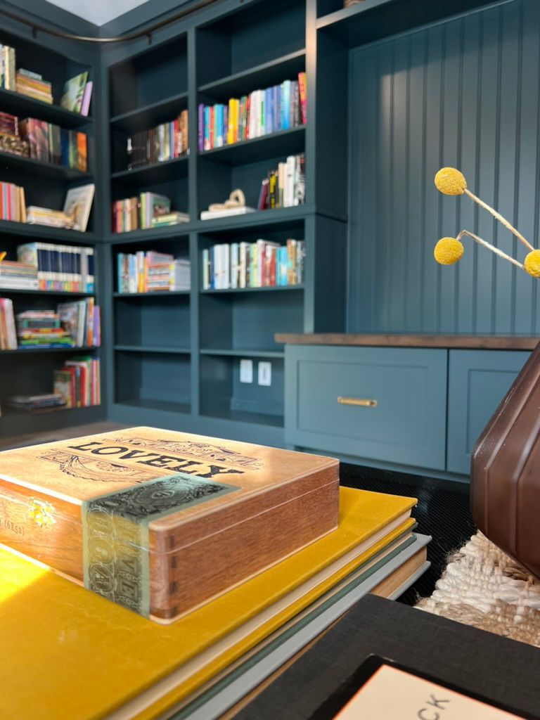 A stack of books on a table in a library with a book that says ' poetry ' on it