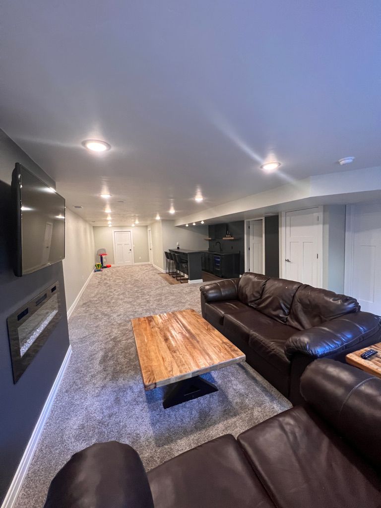 A living room in a basement with a couch and a coffee table.