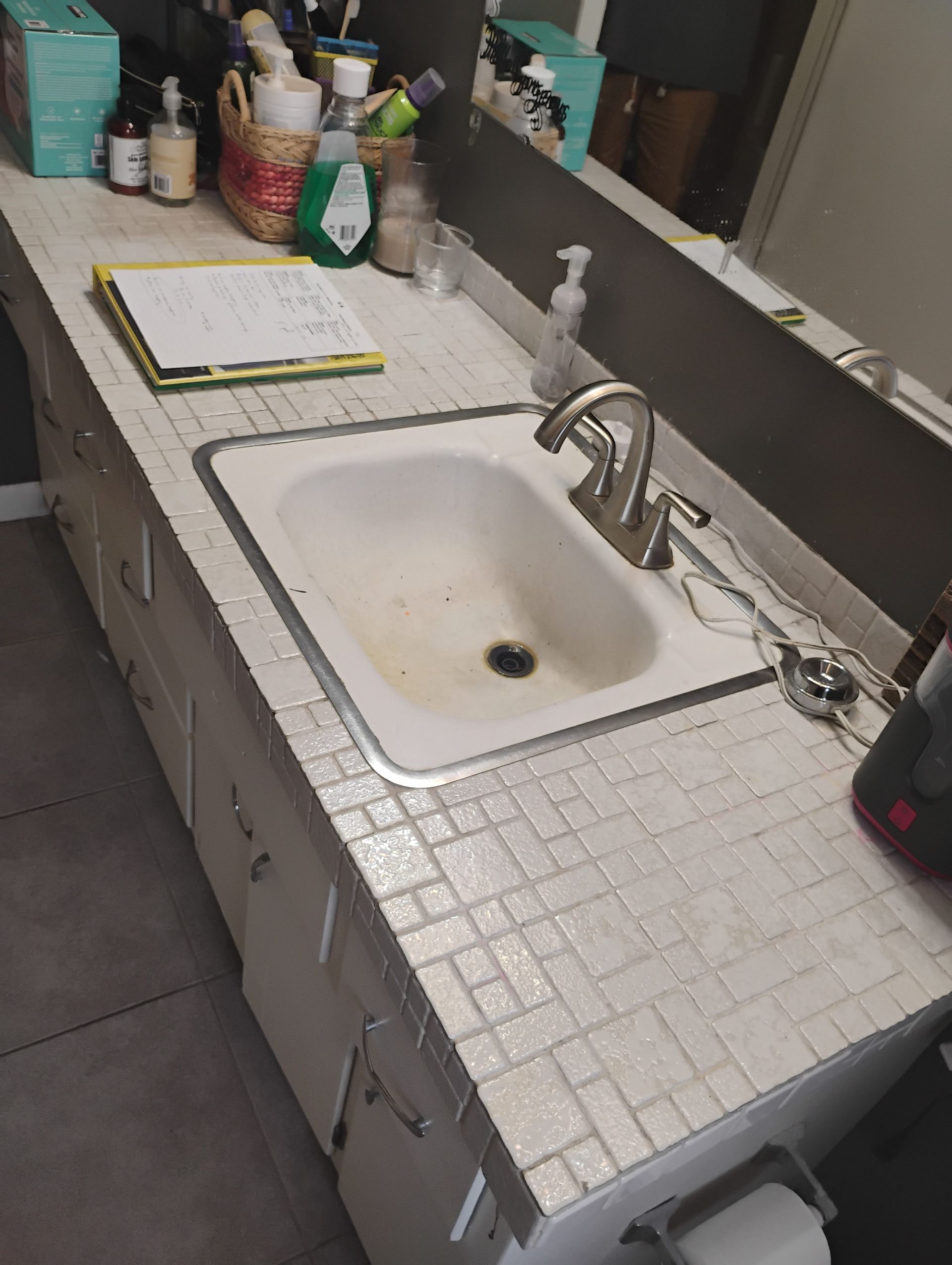 Bathroom sink with white tiled countertop