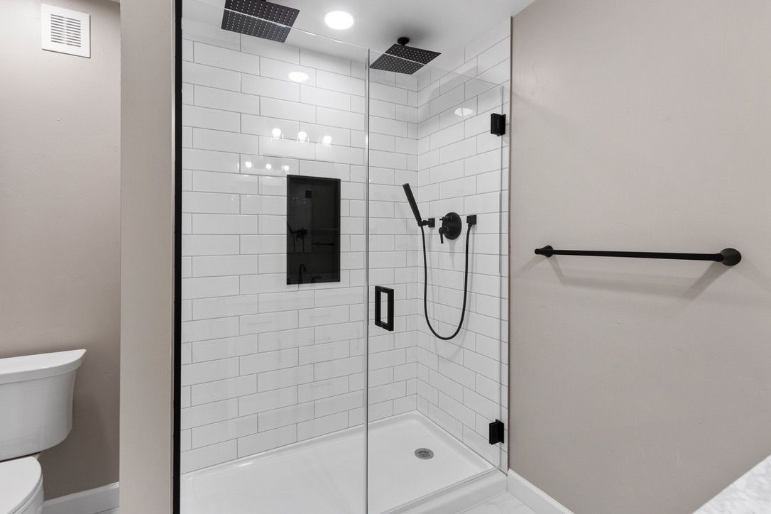 A bathroom with a walk in shower and a toilet.