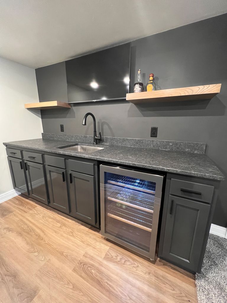 A kitchen with a sink , refrigerator , and television.