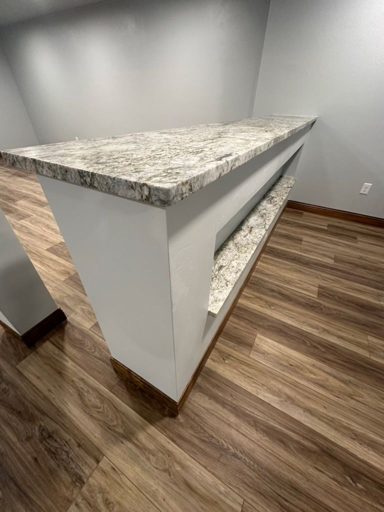 A kitchen with a granite counter top and hardwood floors.