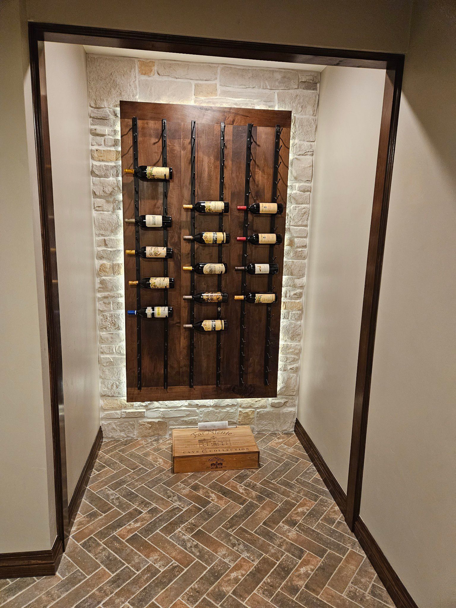 A wine cellar with a wooden wall and bottles of wine on it.