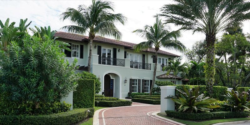 A large white house with palm trees in front of it