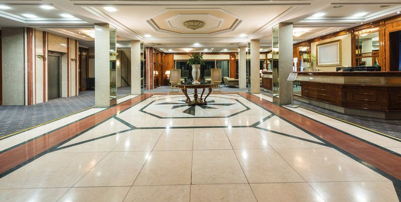 There is a table in the middle of the lobby of a hotel.