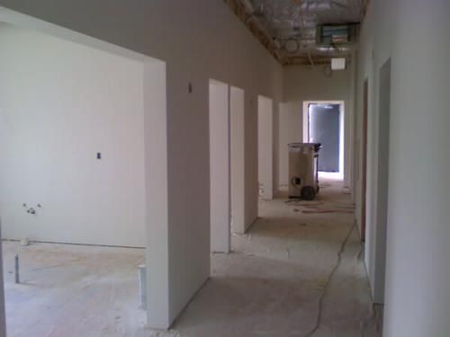 A long hallway with a trash can in the middle of it.