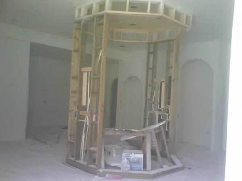 A room with a wooden frame and a ladder in it.