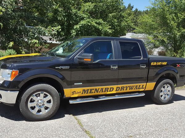 A black truck with the word drywall on the side