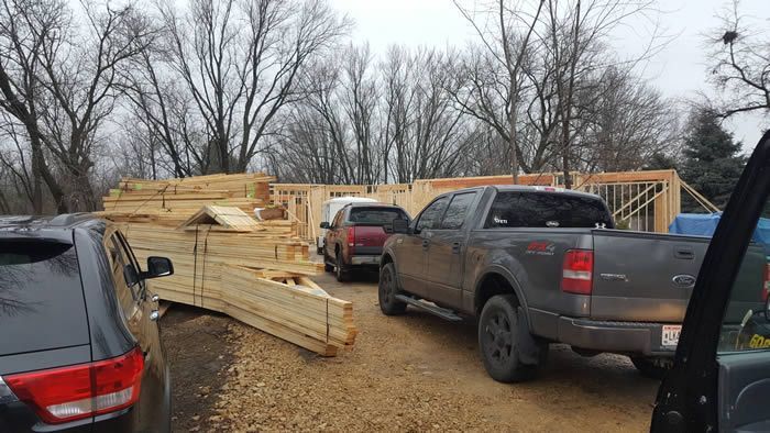A truck is parked in front of a house under construction.
