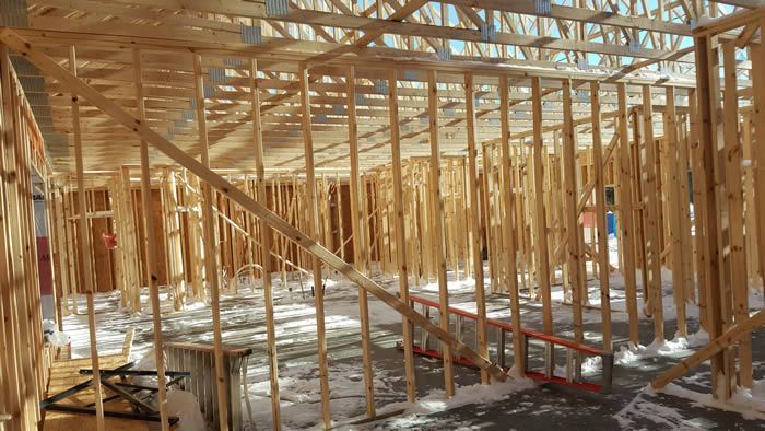 A large wooden structure is being built in the snow.