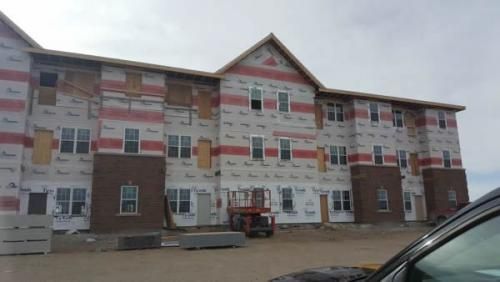A large building under construction with a car parked in front of it.