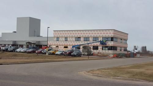 A large building with a lot of cars parked in front of it.